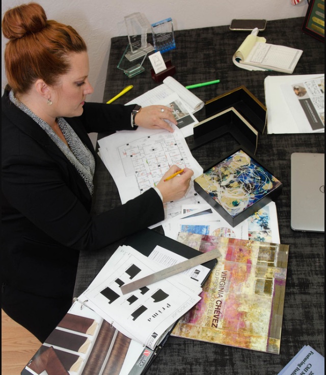 Perimeter Art advisor reviewing frame corner samples and mat layouts at a desk